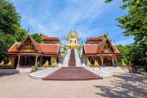 Golden Big Buddha statue at Wat Phra Yai temple with traditional Thai architecture, Koh Samui