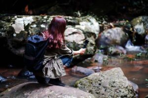 Photographer using action camera to capture Koh Samui waterfall and jungle stream scenery