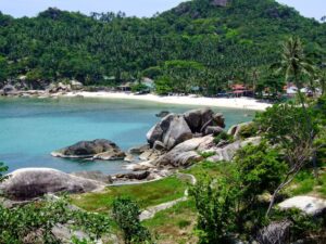Scenic Koh Samui bay with granite boulders, white sand beach and lush tropical hill
