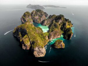 Aerial view of Phi Phi Islands limestone karst formations with emerald lagoons and speedboats