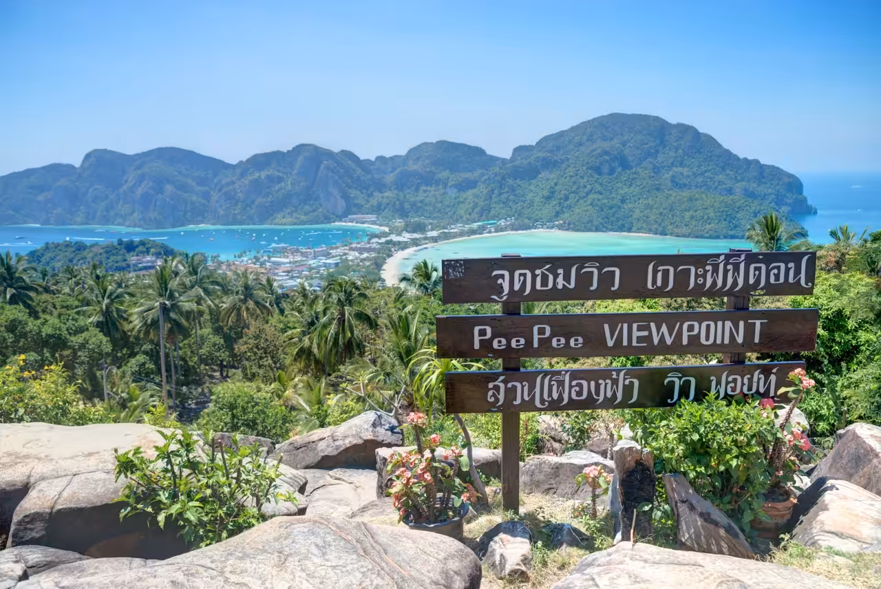 View over Koh Phi Phi Don from the island viewpoint, with a wooden Pee Pee Viewpoint sign overlooking Tonsai Bay